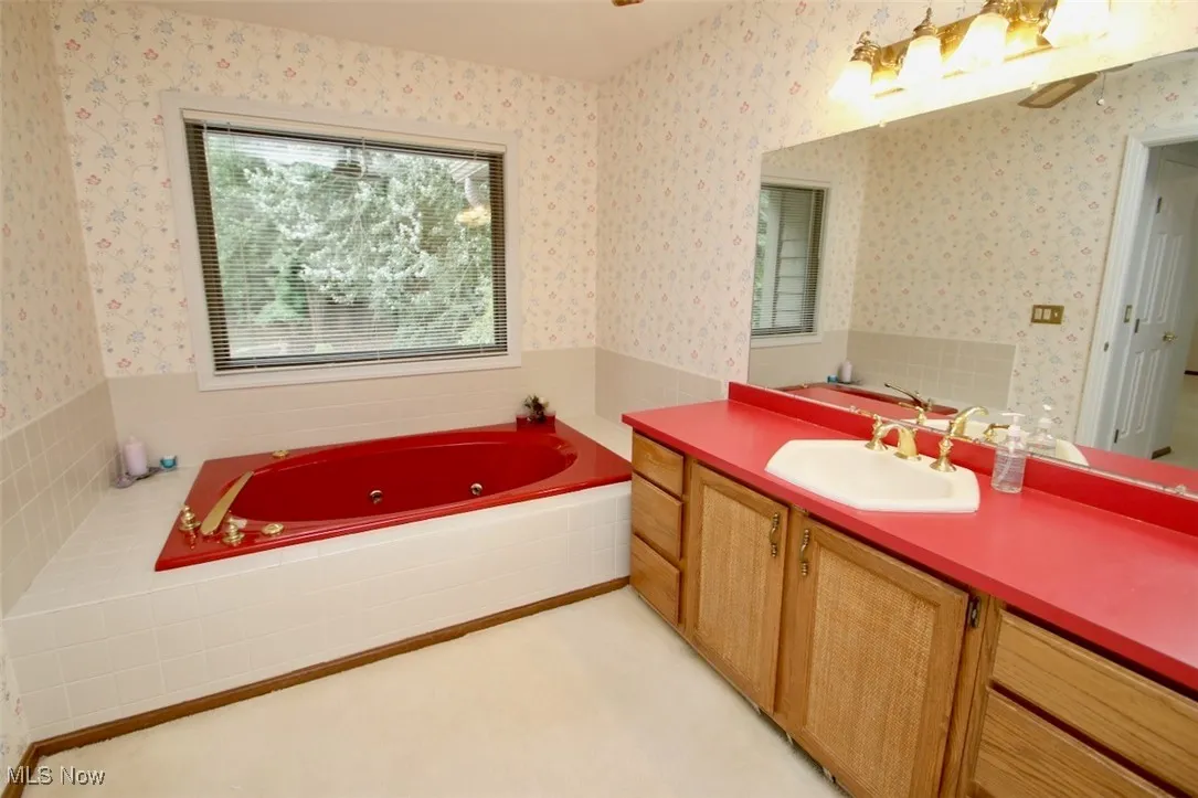 Full bathroom featuring vanity, a jetted tub and separate shower
