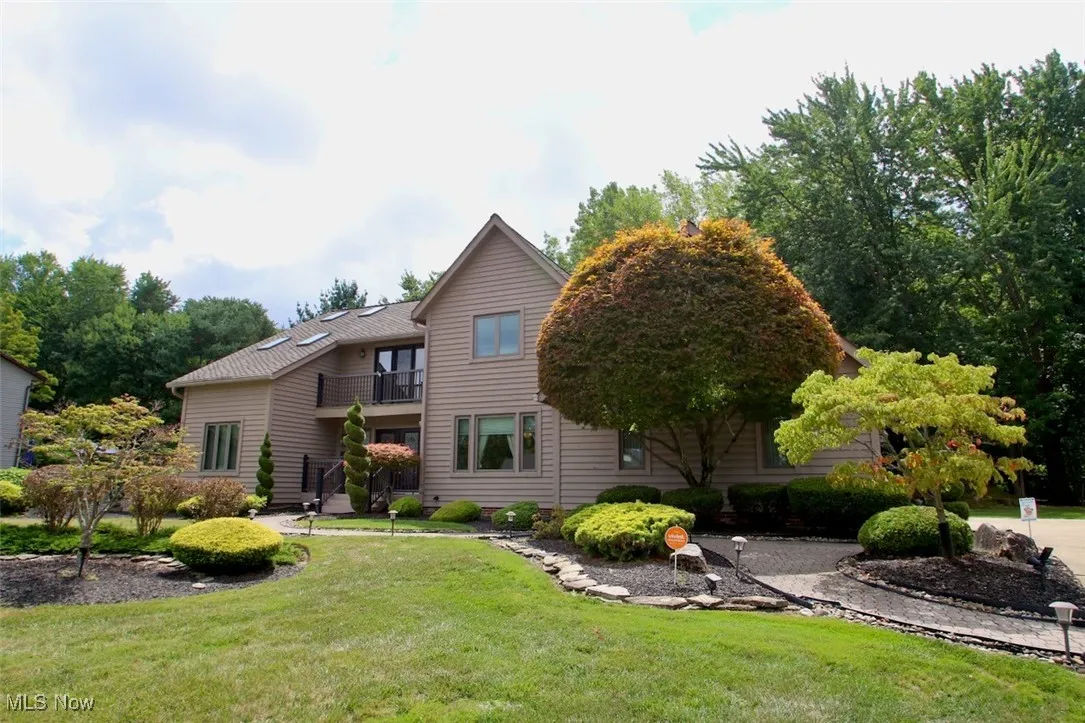 View of front of property with a balcony and a front lawn