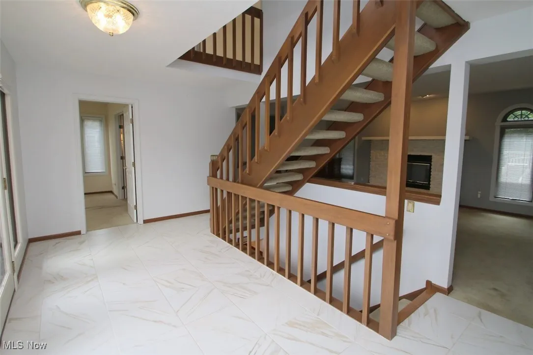Staircase with plenty of natural light and carpet