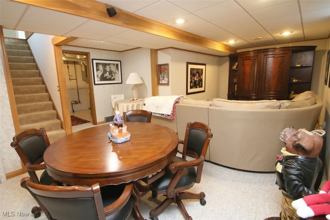 Dining room with stairway, a drop ceiling, carpet flooring, and recessed lighting