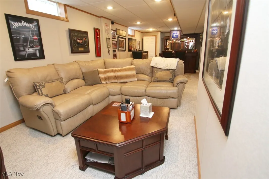 Carpeted living area featuring a drop ceiling and recessed lighting