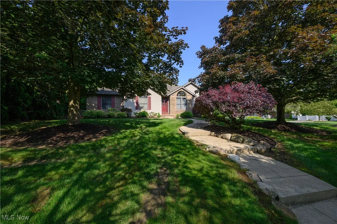 View of property featuring a front yard and brick siding