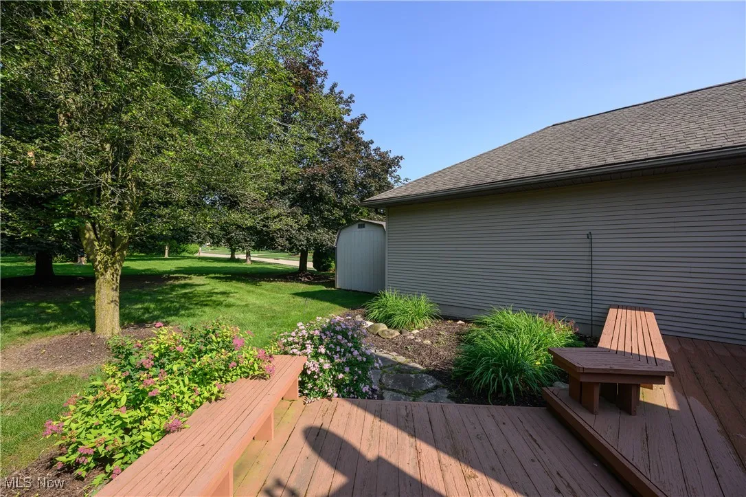 Wooden terrace with a storage unit and a yard