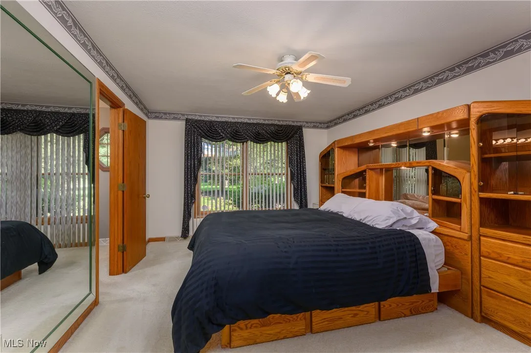 Bedroom with carpet floors, access to exterior, and a ceiling fan