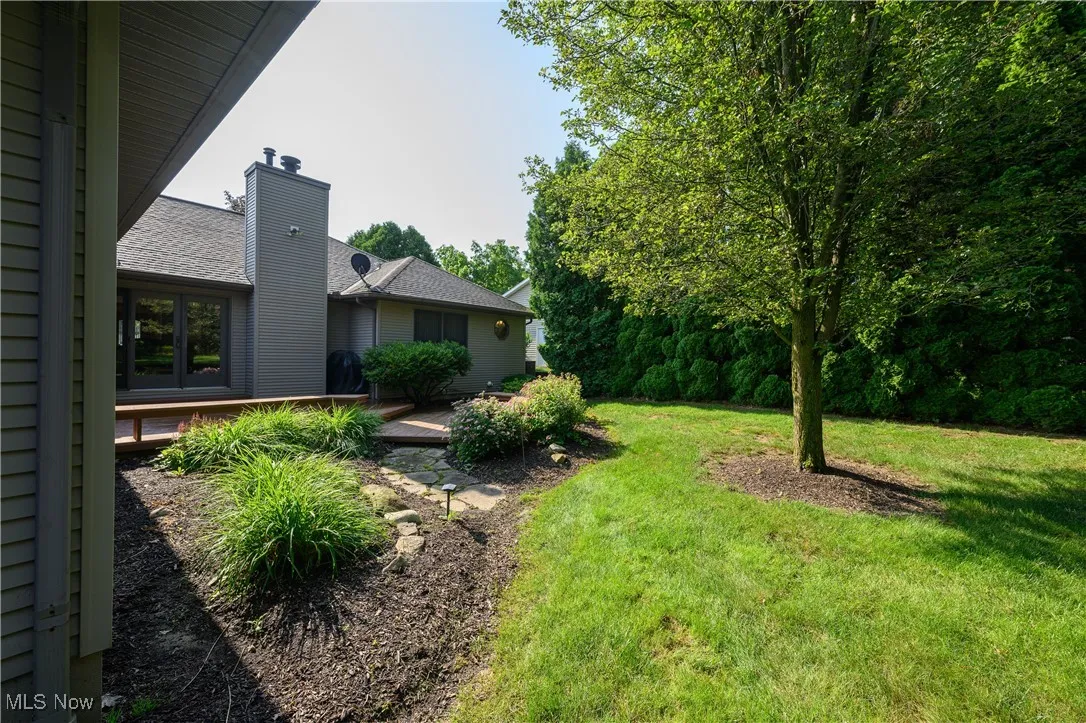 View of grassy yard featuring a deck