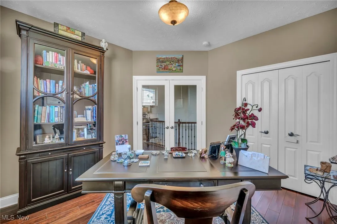 Dining area featuring a textured ceiling, dark wood finished floors, and french doors
