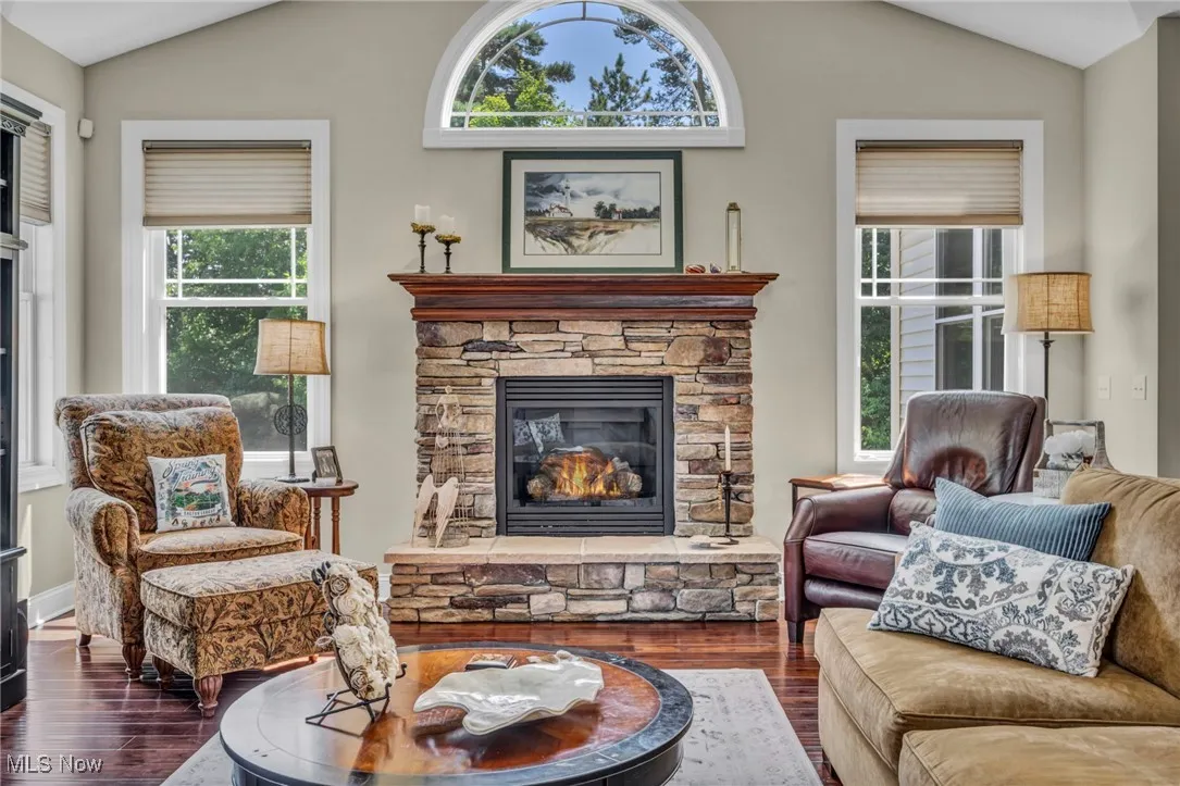 Living area with lofted ceiling, wood finished floors, and a fireplace