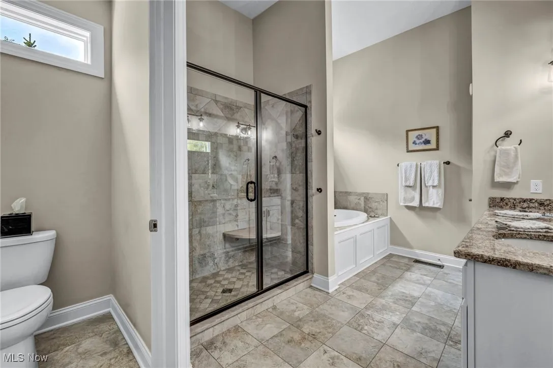 Full bath featuring a garden tub, a stall shower, and double vanity