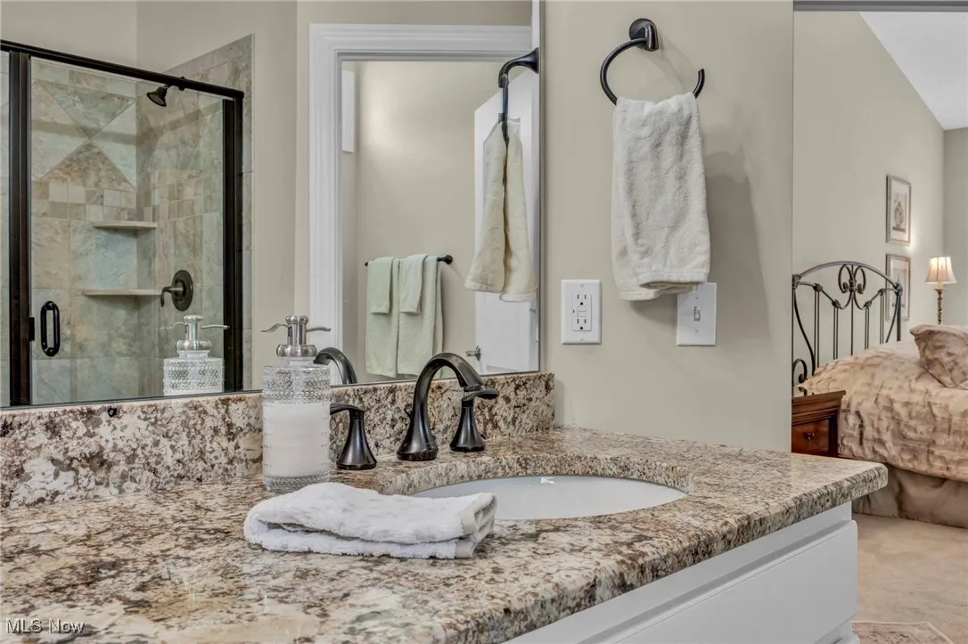 Bathroom featuring a stall shower, vanity, and ensuite bath