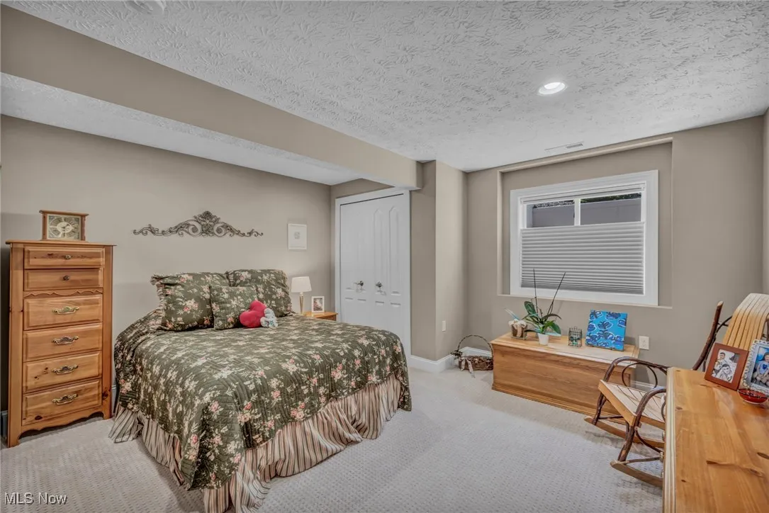 Bedroom featuring carpet flooring, a textured ceiling, and a closet