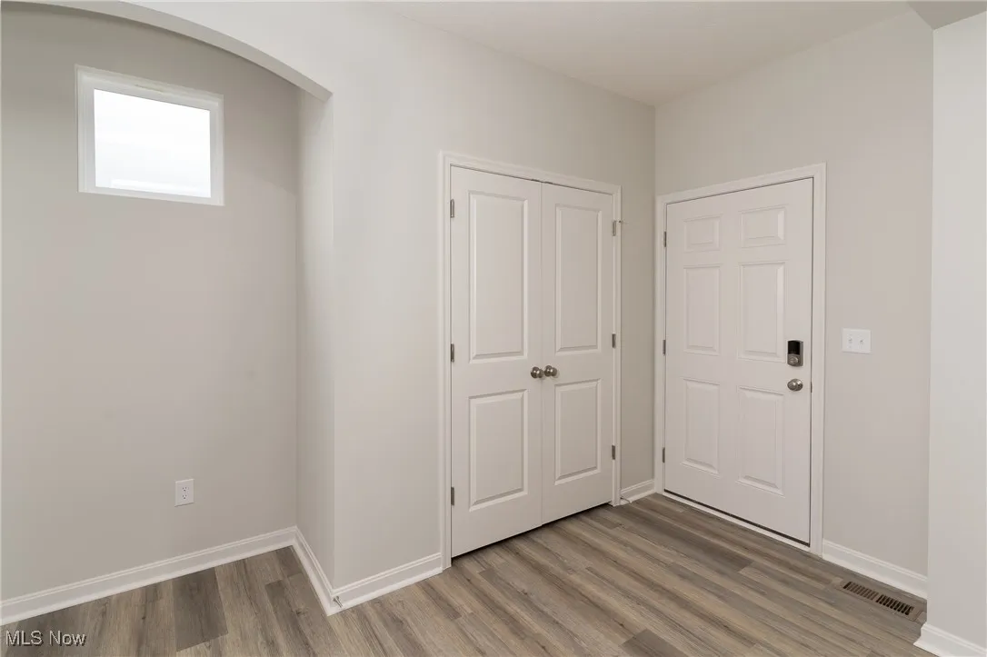 Foyer entrance featuring wood finished floors and arched walkways