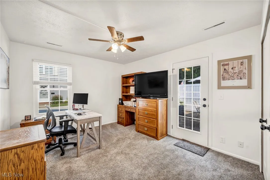 Office space featuring light colored carpet and ceiling fan