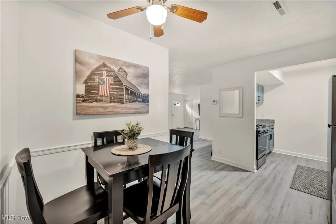 Dining room with light wood-style flooring and ceiling fan