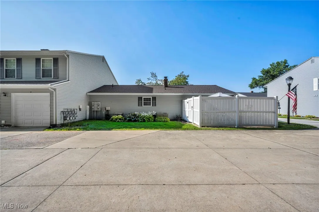 View of property exterior featuring concrete driveway, an attached garage, and a shingled roof