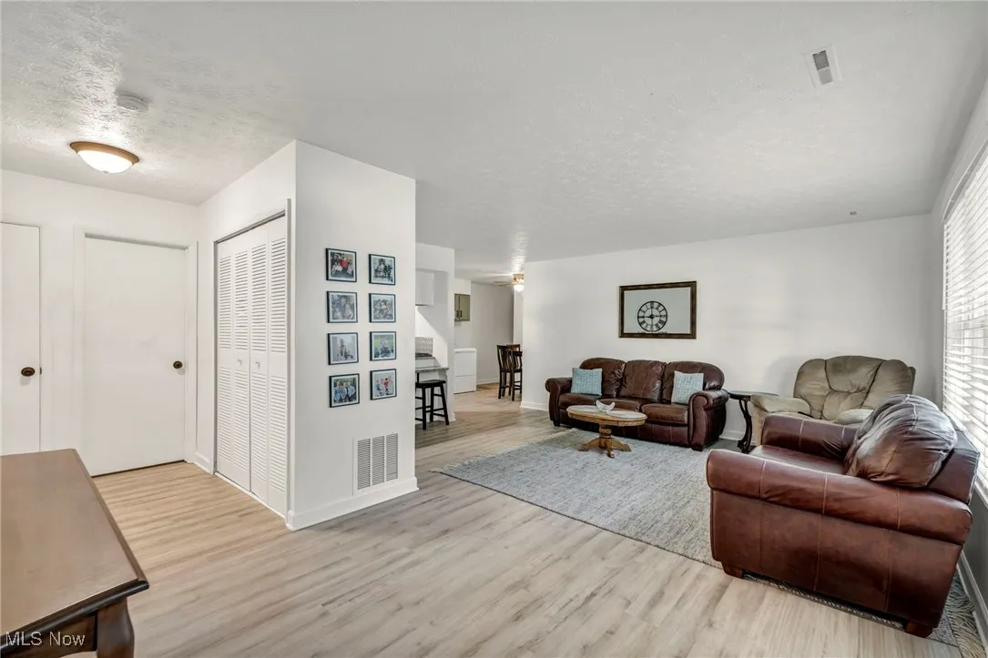 Living area with a textured ceiling and light wood finished floors