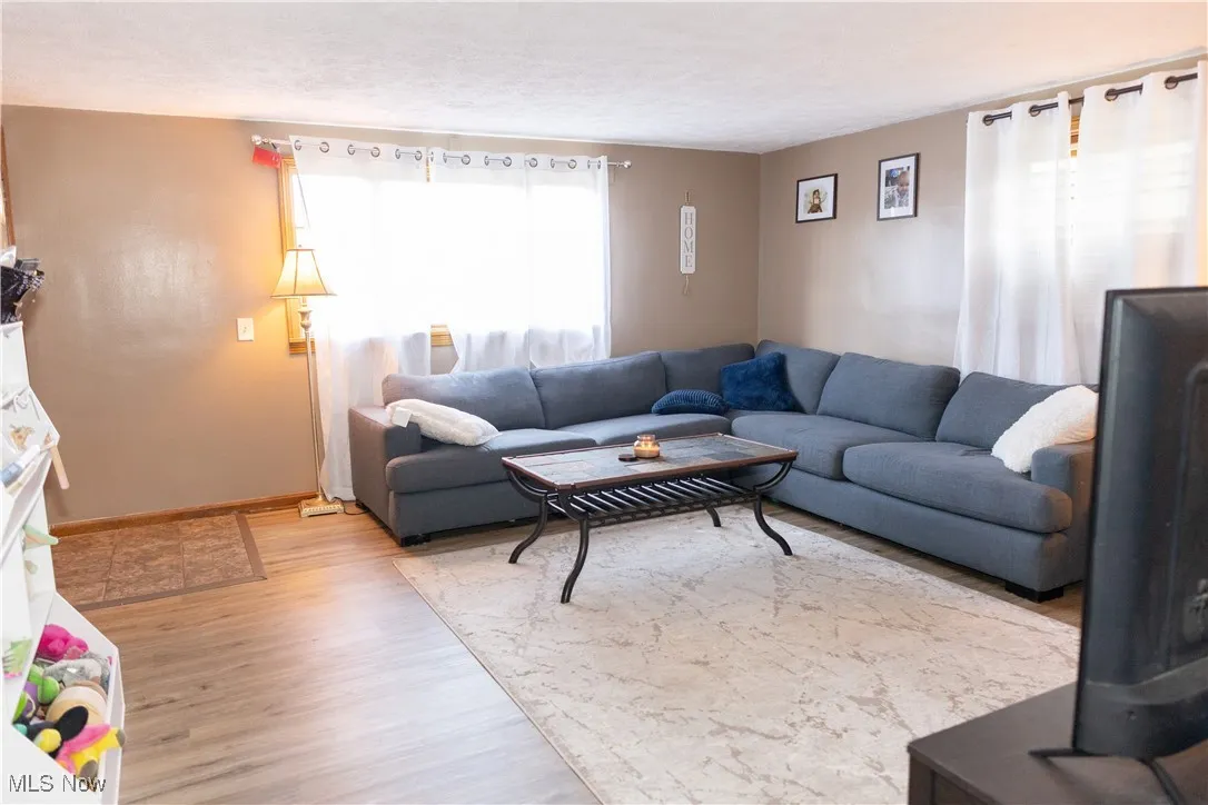 Living area featuring light wood-type flooring and baseboards