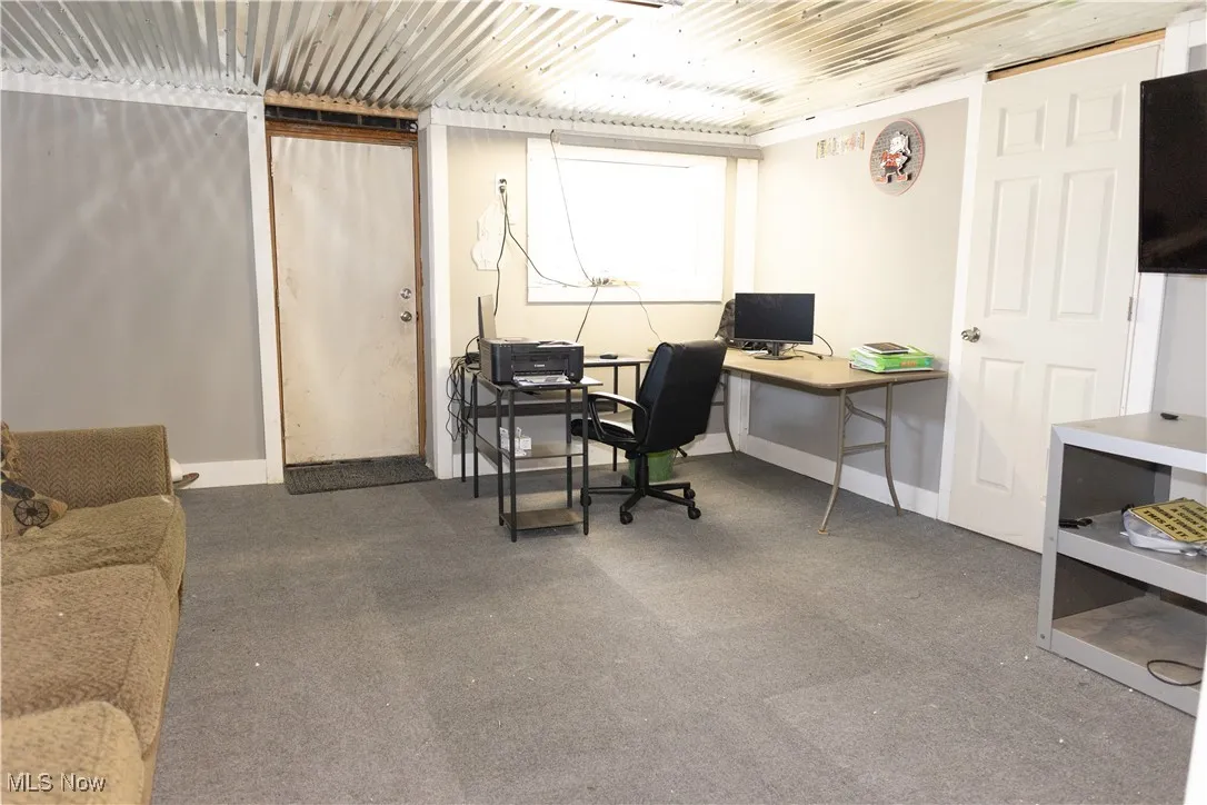 Carpeted office space featuring baseboards