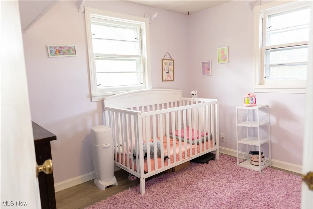 Bedroom featuring a crib and light wood-style flooring