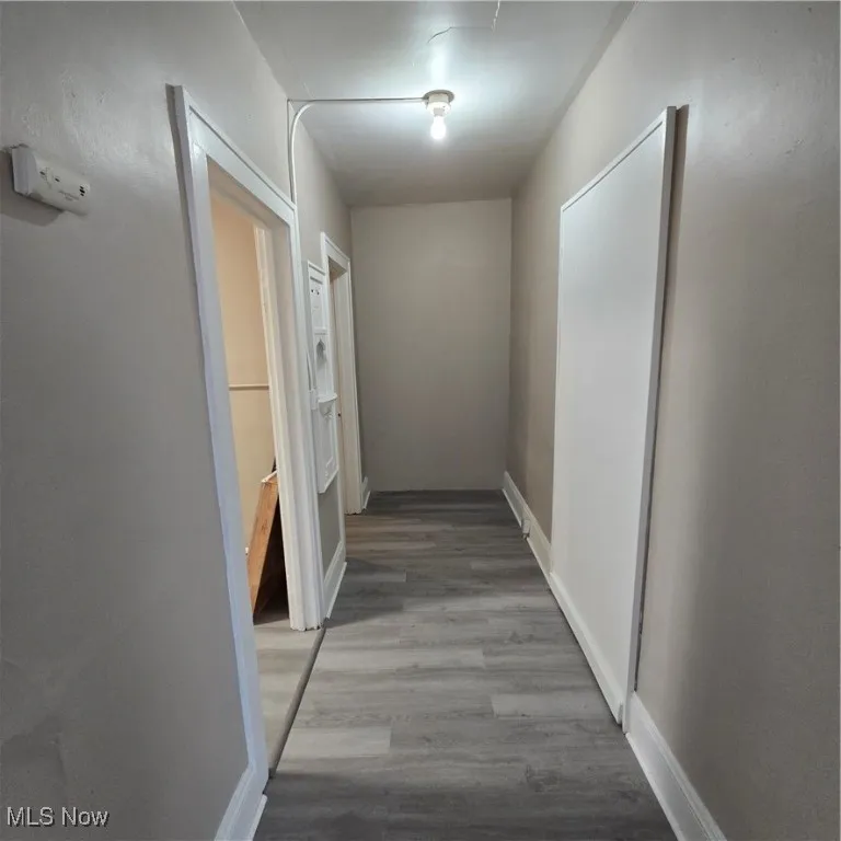 Hallway with wood finished floors and baseboards