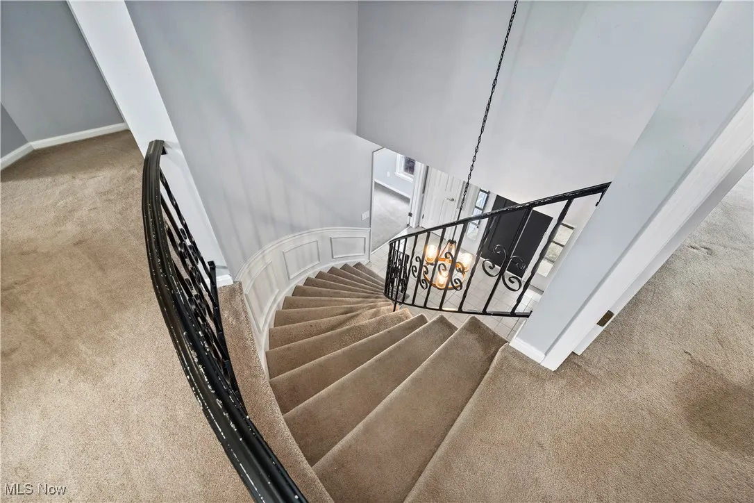 Staircase with carpet floors and baseboards