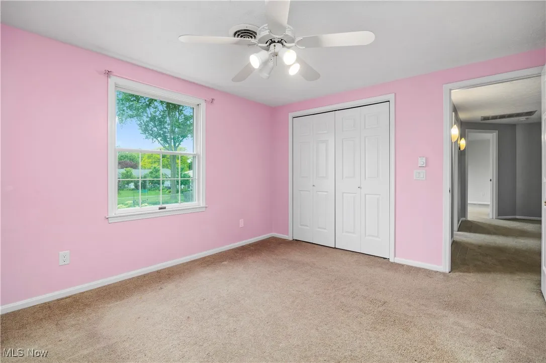 Unfurnished bedroom with carpet, a closet, and ceiling fan