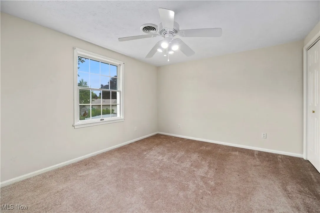 Spare room with carpet floors and a ceiling fan