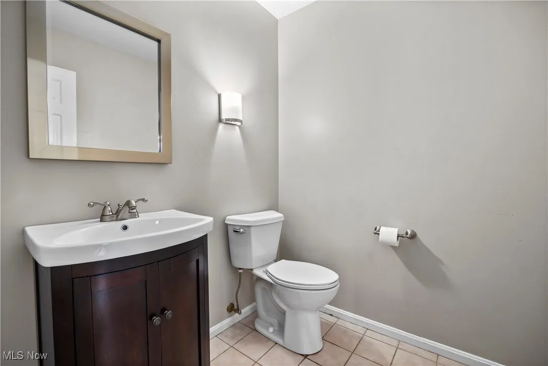 Half bath featuring vanity and tile patterned flooring
