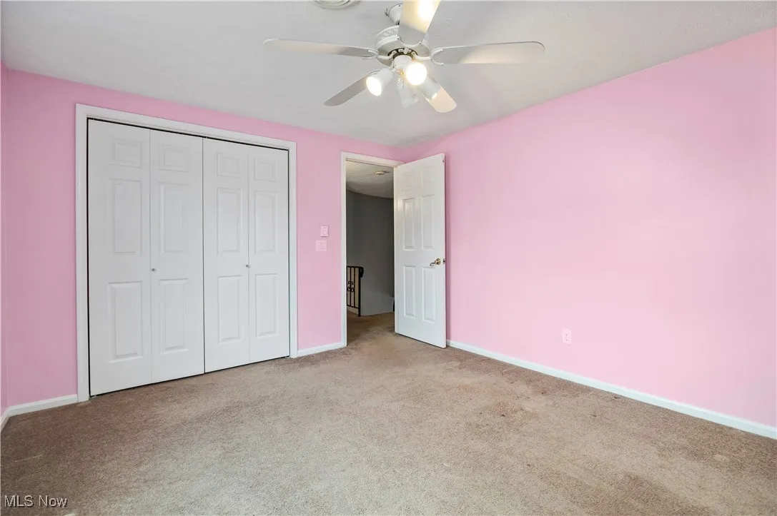 Unfurnished bedroom with carpet flooring, a closet, and ceiling fan
