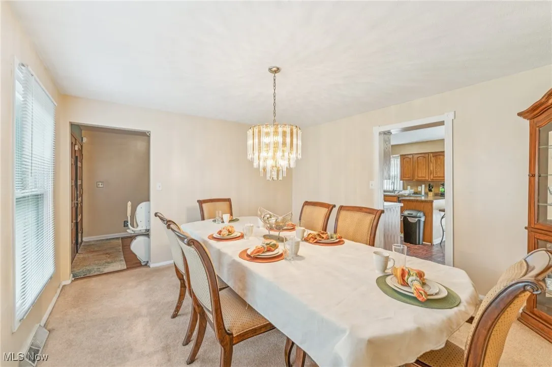 Dining room featuring a chandelier and light carpet