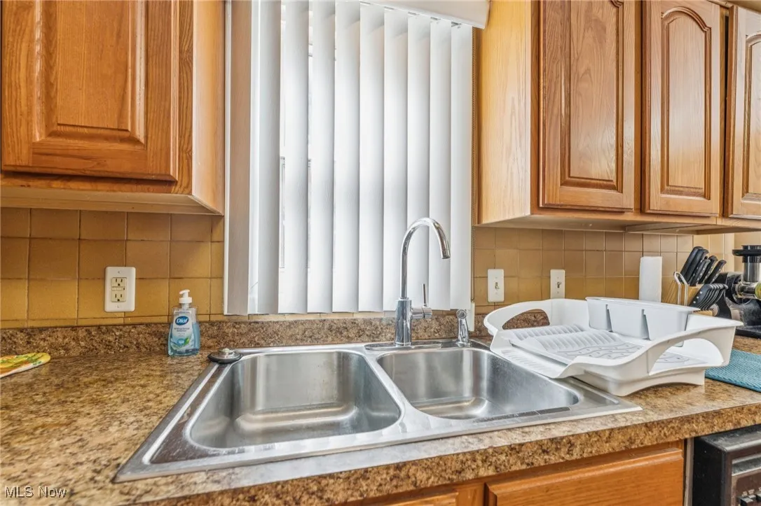 Kitchen featuring backsplash, brown cabinets, and light countertops