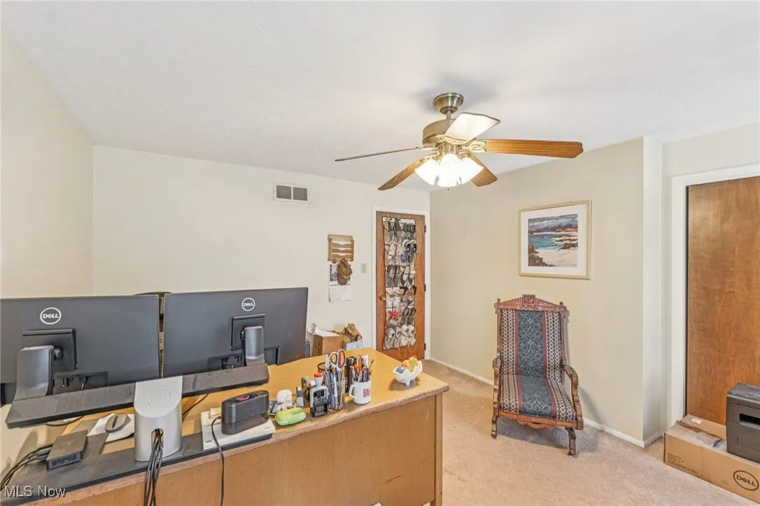 Office area featuring light colored carpet and a ceiling fan