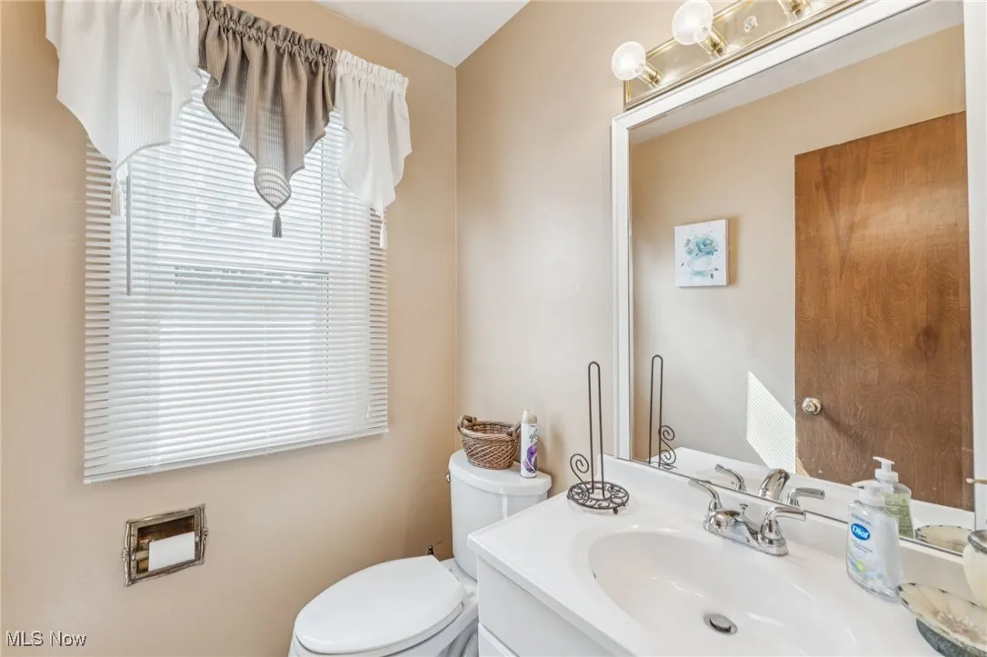 Half bathroom with vanity and toilet