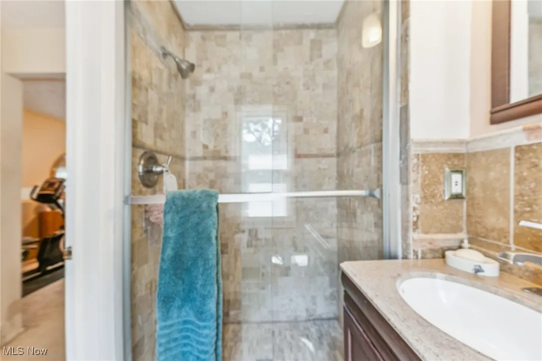 Full bathroom with vanity and a shower stall