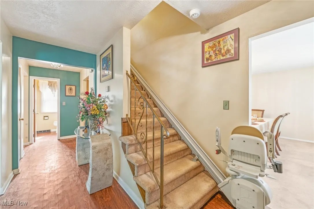 Staircase featuring wood finished floors and a textured ceiling