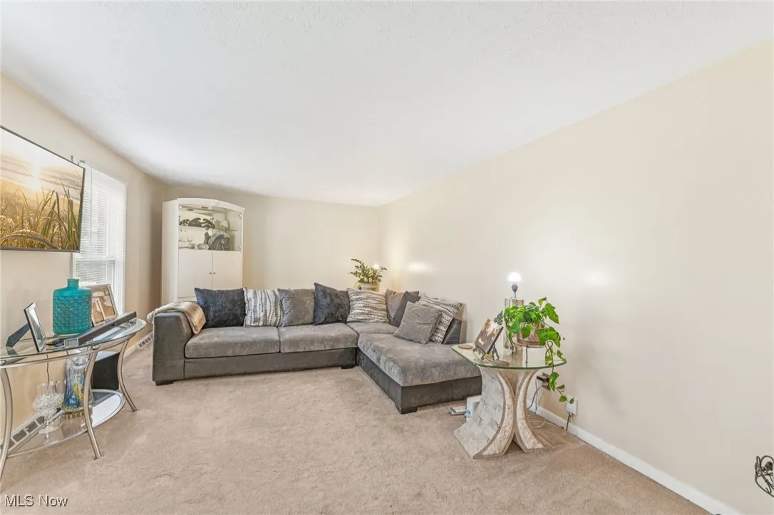 Carpeted living area featuring baseboards
