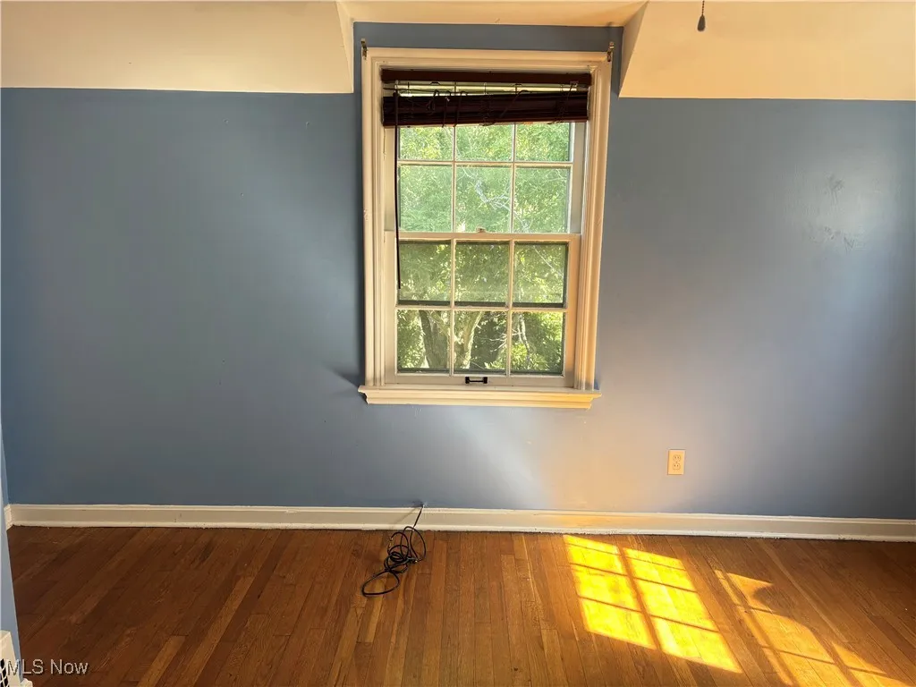 Empty room with baseboards and wood finished floors