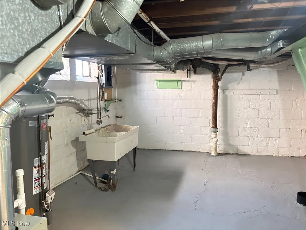 Below grade area with a sink and water heater