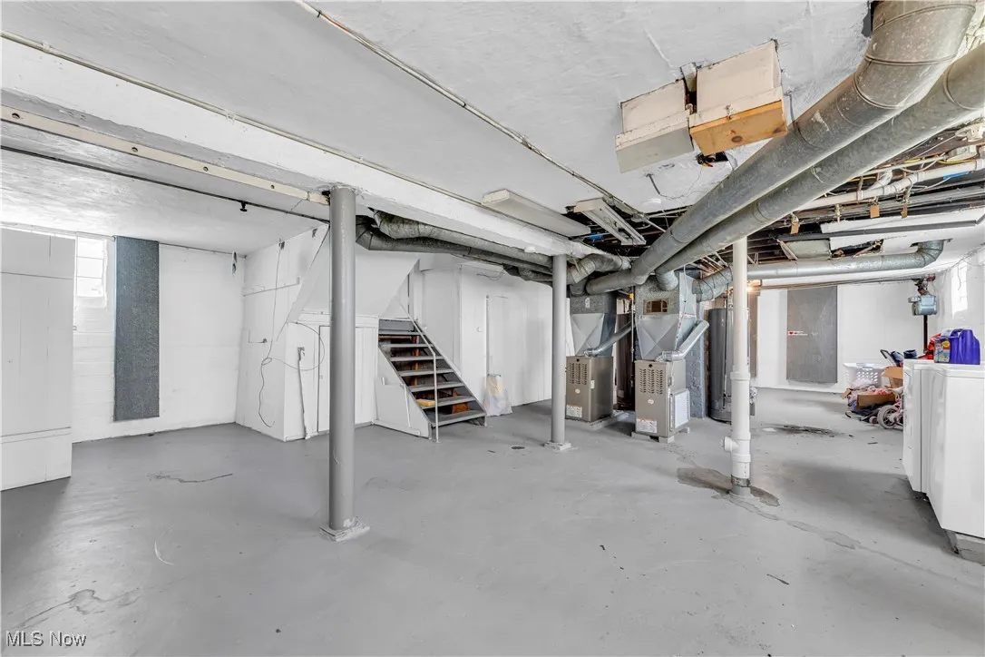 Basement featuring stairs, washer / dryer, heating unit, and water heater