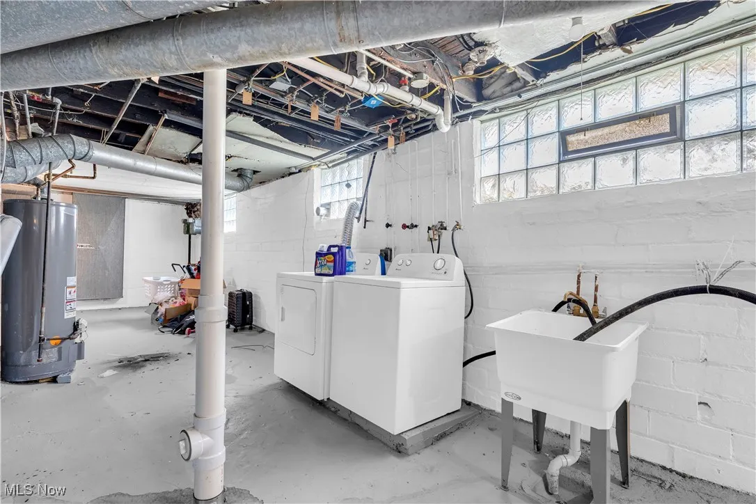 Washroom with water heater and washer and clothes dryer