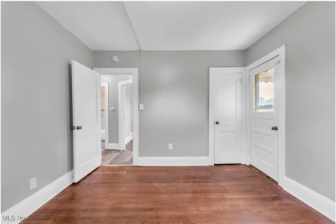 Unfurnished bedroom featuring wood finished floors and baseboards