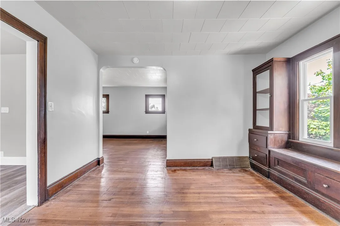 Unfurnished room featuring arched walkways and light wood finished floors