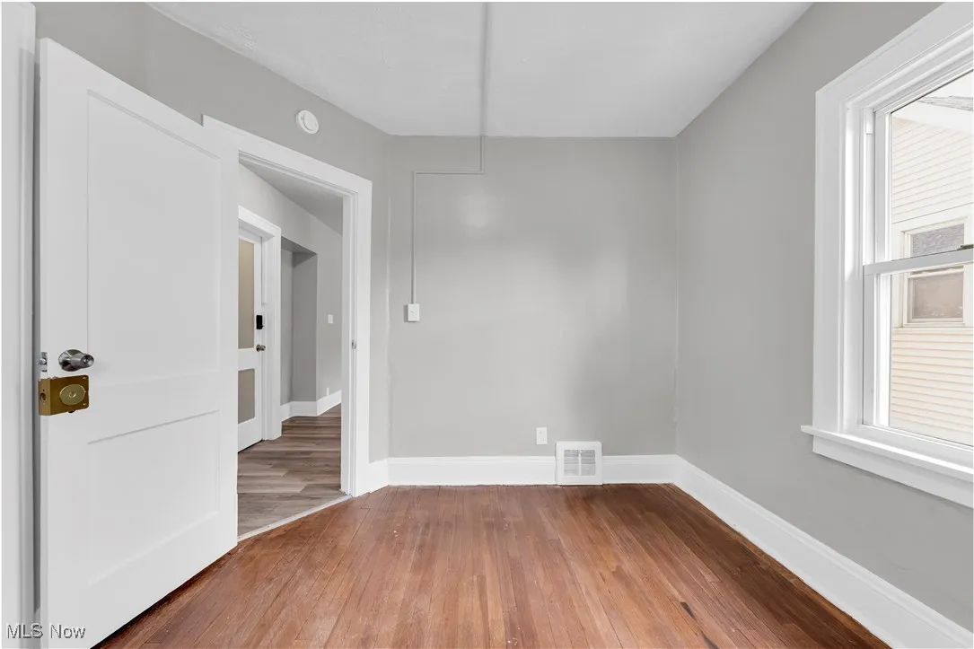 Unfurnished room featuring hardwood / wood-style flooring and baseboards