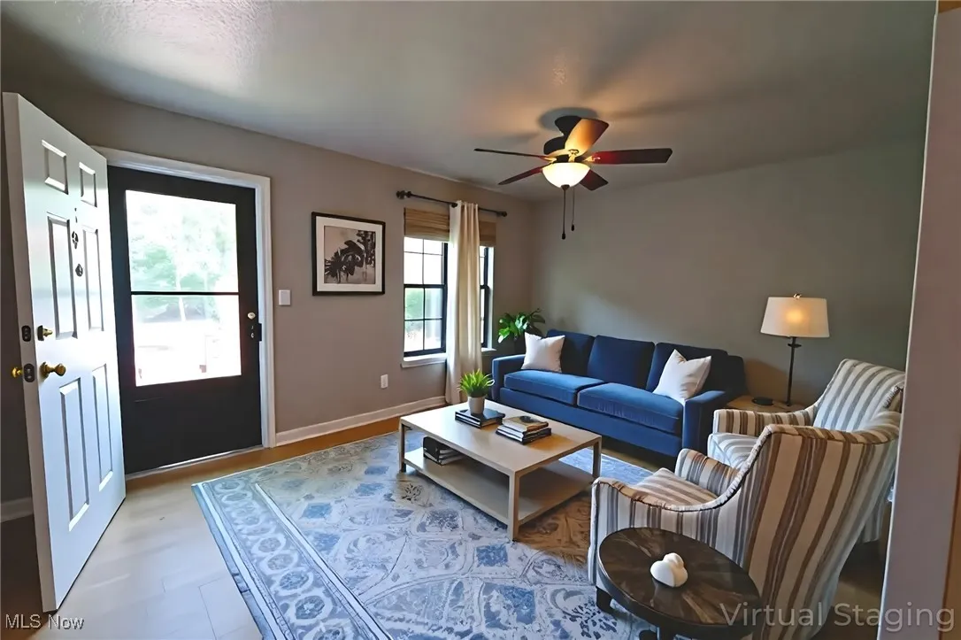 Living area with a ceiling fan and baseboards