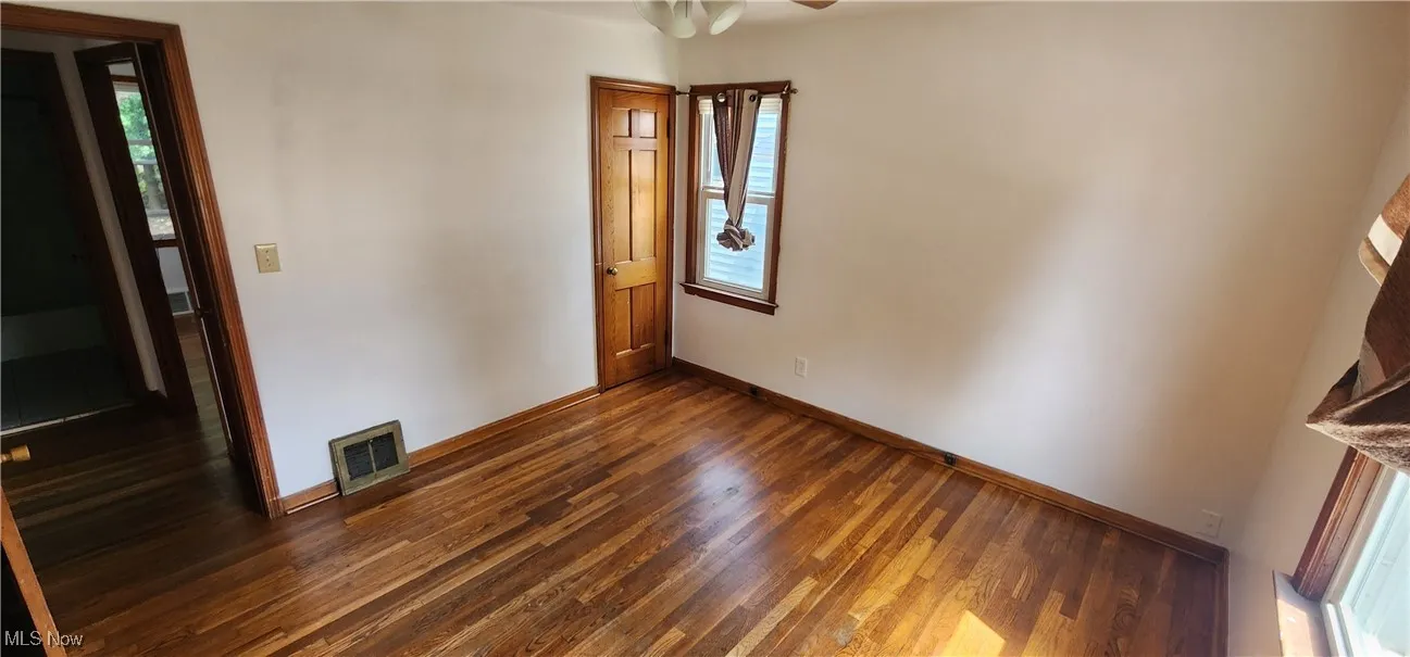 Unfurnished room with wood finished floors and a ceiling fan