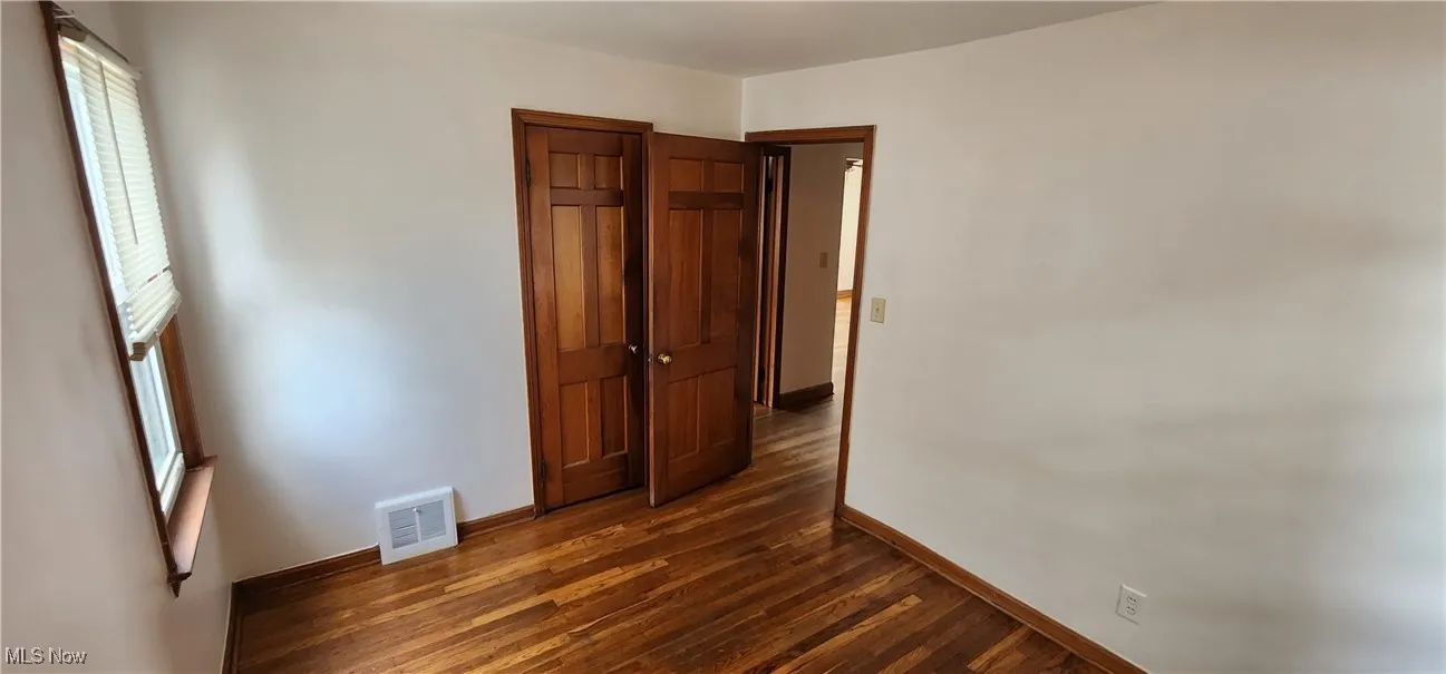 Unfurnished bedroom with dark wood finished floors and a closet