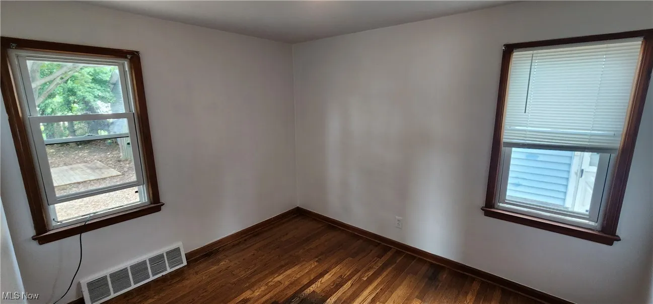 Unfurnished room featuring healthy amount of natural light and dark wood finished floors