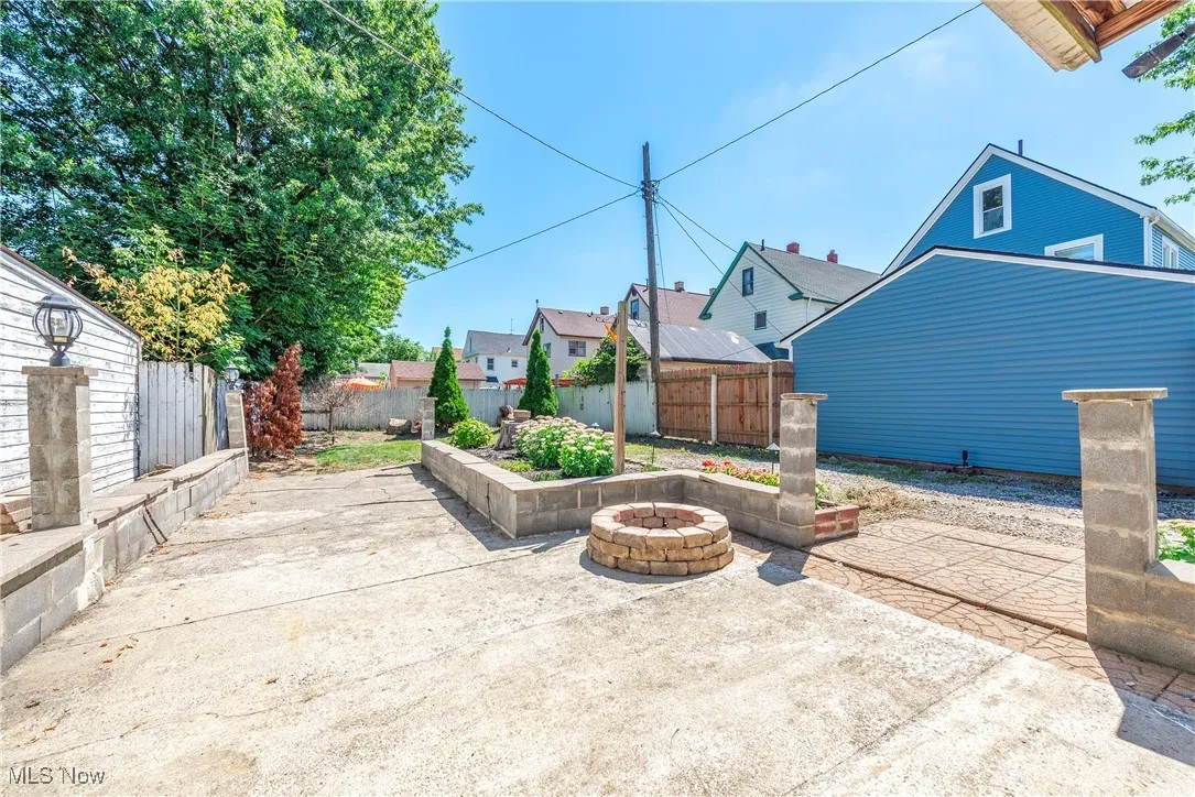 View of patio with an outdoor fire pit and a residential view