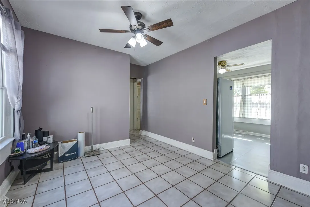 Unfurnished room with light tile patterned floors and a ceiling fan
