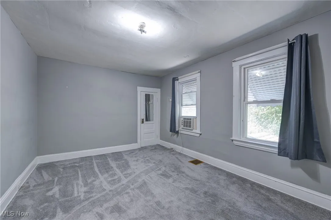 Unfurnished room with light carpet and baseboards