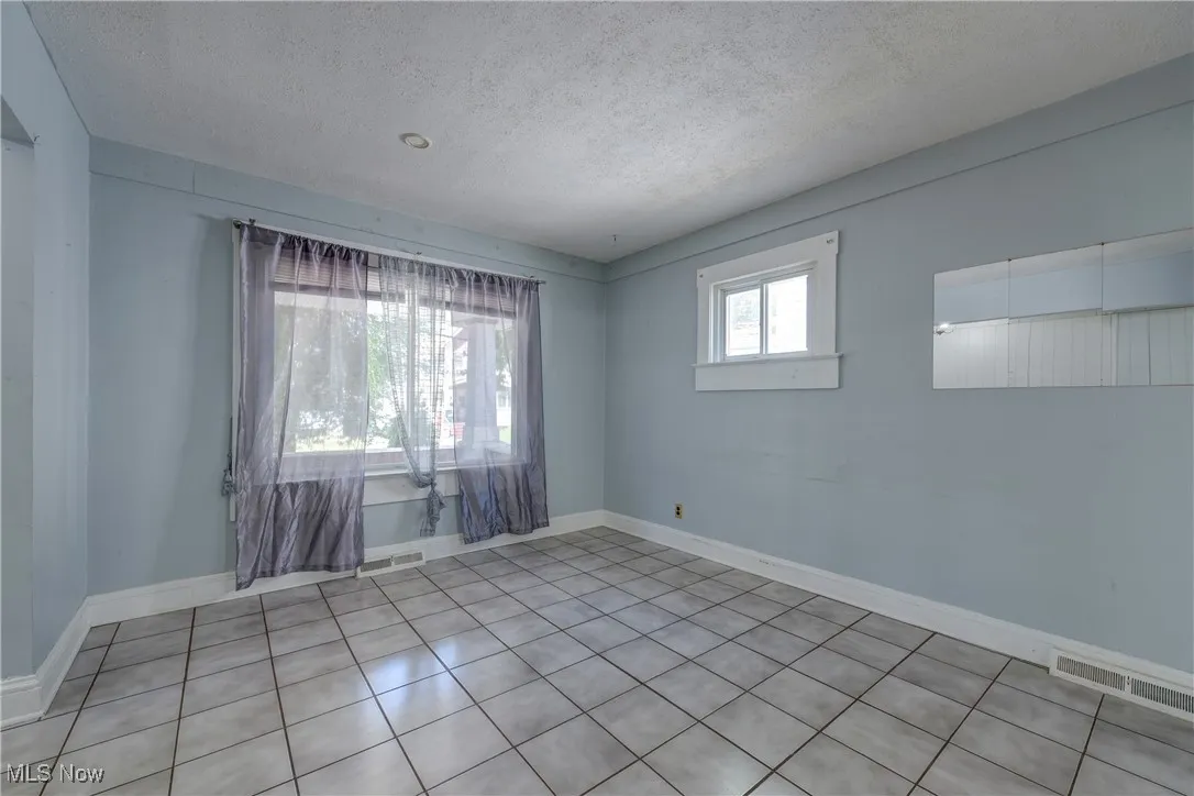 Spare room with a textured ceiling and tile patterned flooring